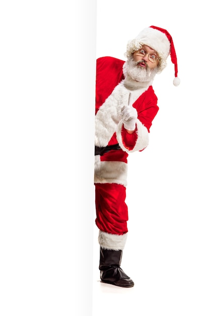Glücklich überrascht Weihnachtsmann zeigt auf leere Werbung