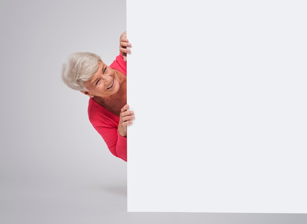 Glückliche ältere Frau hinter dem Whiteboard