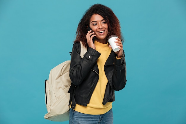 Glückliche afrikanische Frau, die per Telefon spricht.