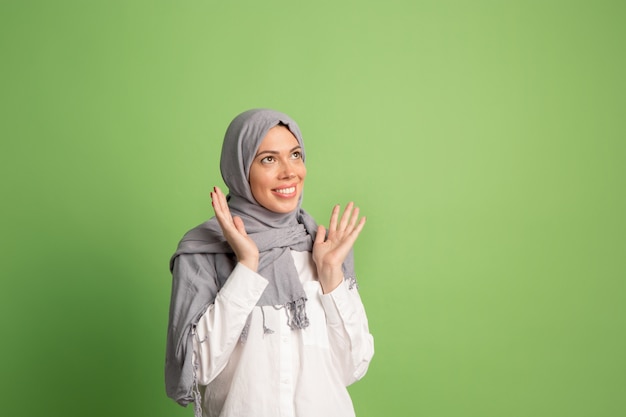 Glückliche arabische Frau im Hijab. Porträt des lächelnden Mädchens, das am Studiohintergrund aufwirft