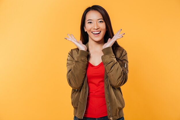 Glückliche asiatische Frau im Jackenhändchenhalten nähern sich Kopf