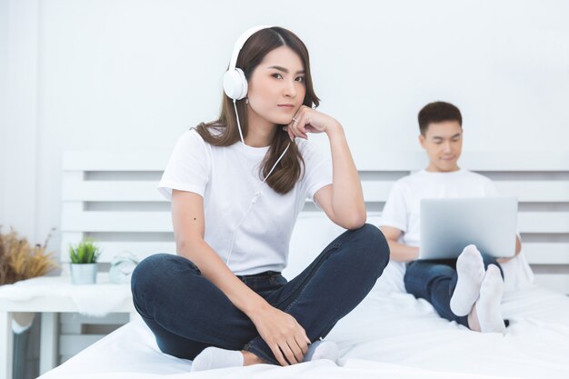 Glückliche asiatische Paare auf dem Bett zu Hause