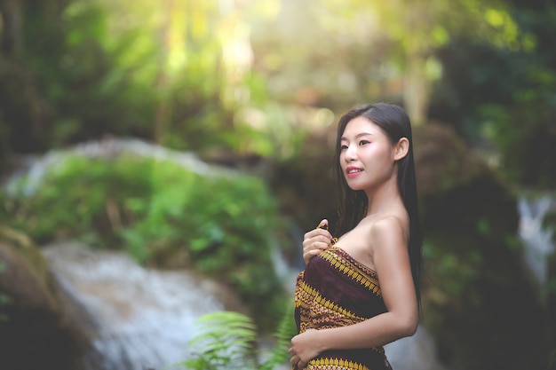 Glückliche badende Frauen am natürlichen Wasserfall