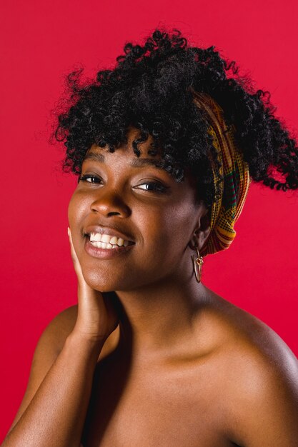 Glückliche bloße afrikanische junge Frau im Studio