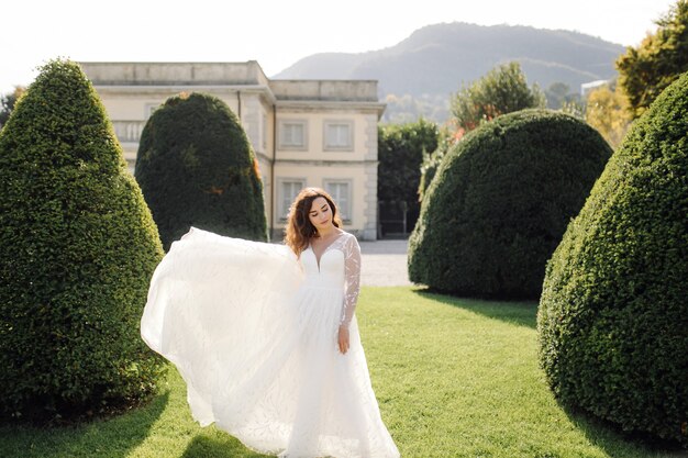 Glückliche Brautfrau in einem Hochzeitskleid, das aufwirft