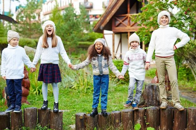 Glückliche draußen spielende und schreiende Kinder