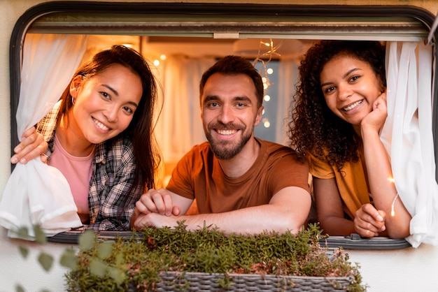 Kostenloses Foto glückliche drei freunde, die vom fenster schauen