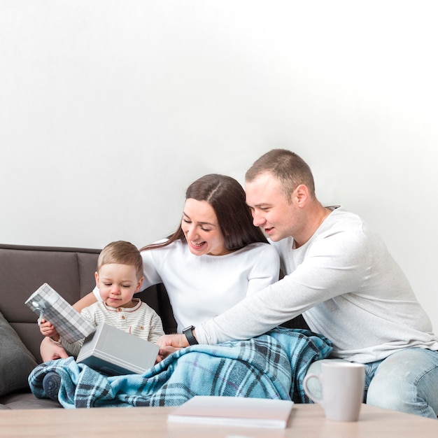 Glückliche Eltern auf der Couch mit Kind