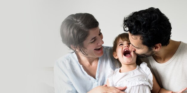 Glückliche Eltern, die zusammen mit Tochter lachen