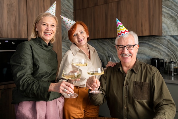 Glückliche familie des mittleren schusses, die gläser hält