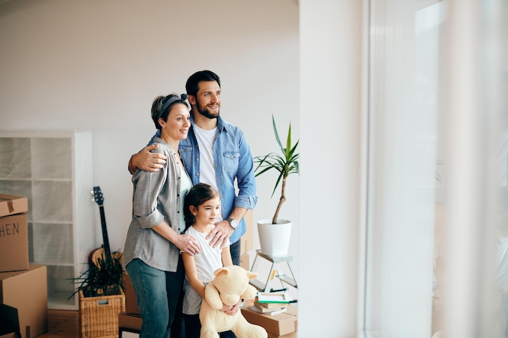 Kostenlose Foto glückliche familie, die beim umzug in ein neues zuhause durch das fenster schaut