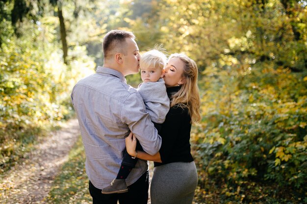 glückliche Familie, die im Herbstpark spielt und lacht