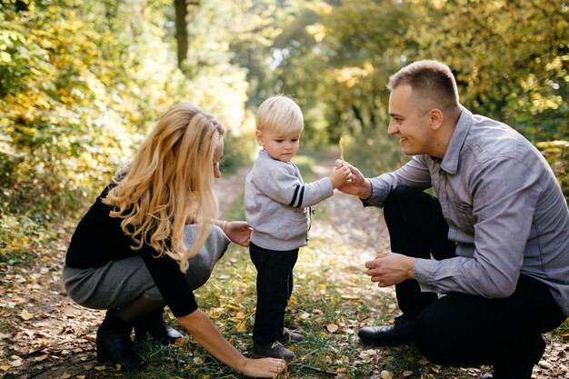 glückliche Familie, die im Herbstpark spielt und lacht