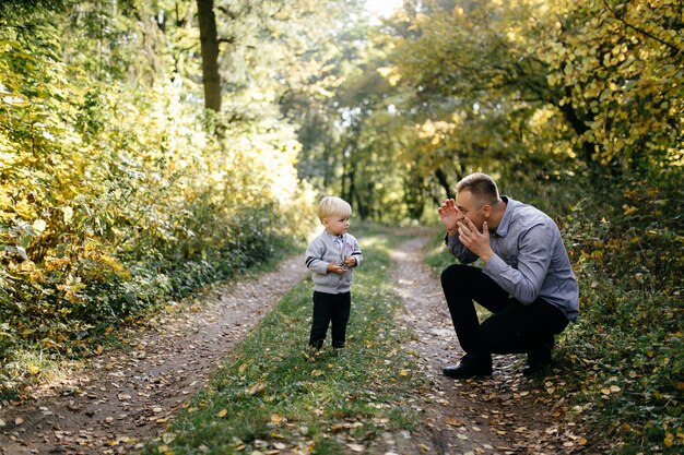 glückliche Familie, die im Herbstpark spielt und lacht