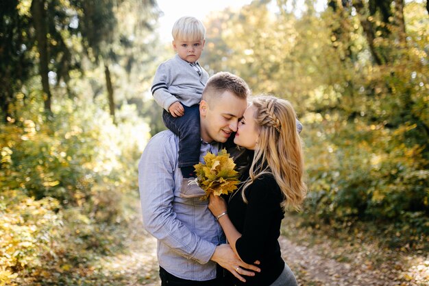 glückliche Familie, die im Herbstpark spielt und lacht