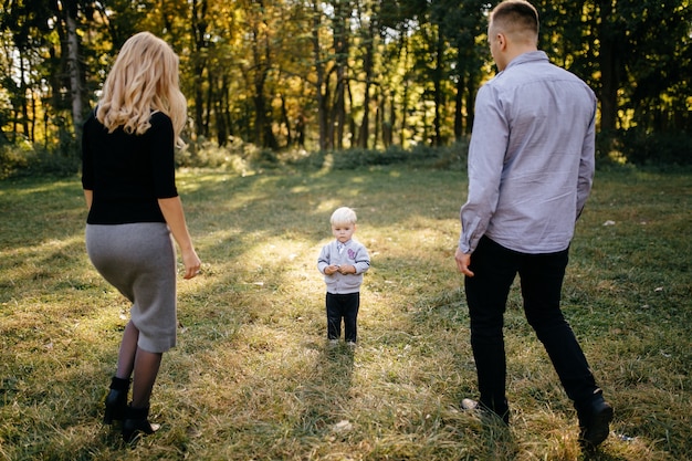 glückliche Familie, die im Herbstpark spielt und lacht