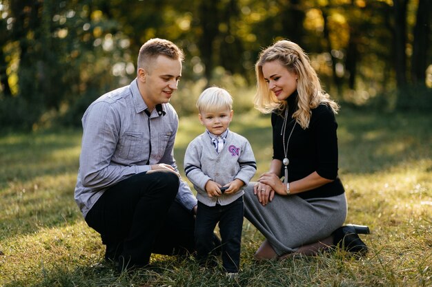 glückliche Familie, die im Herbstpark spielt und lacht