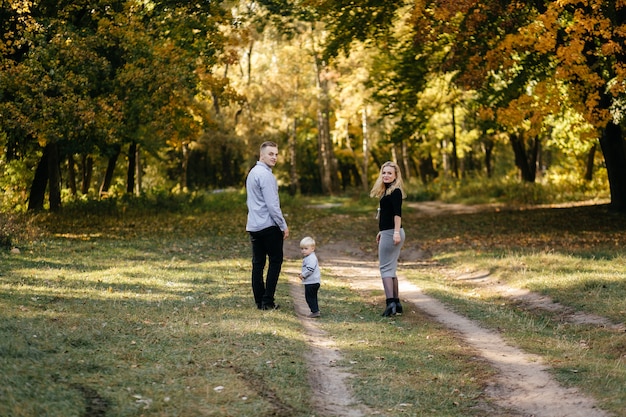 glückliche Familie, die im Herbstpark spielt und lacht