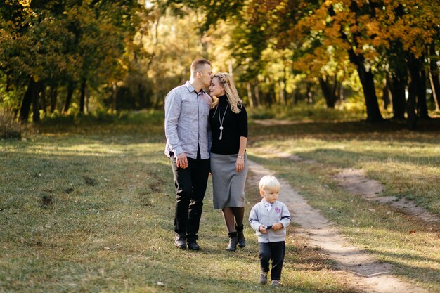 glückliche Familie, die im Herbstpark spielt und lacht