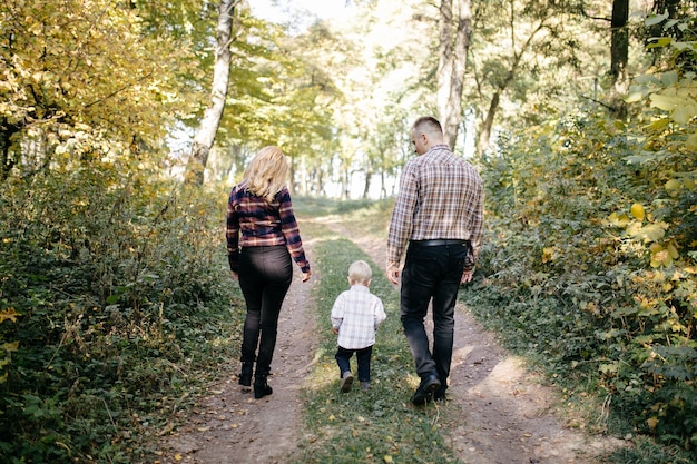 glückliche Familie, die im Herbstpark spielt und lacht