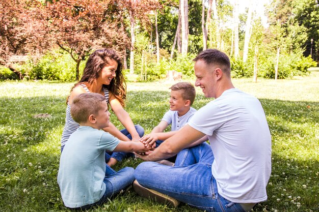 Glückliche Familie, die im Park sitzt