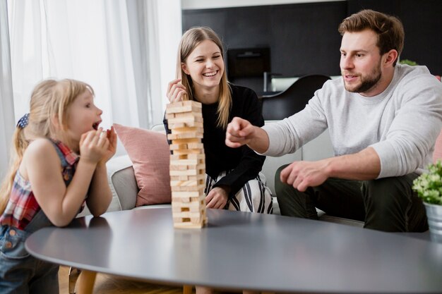 Glückliche Familie, die jenga spielt