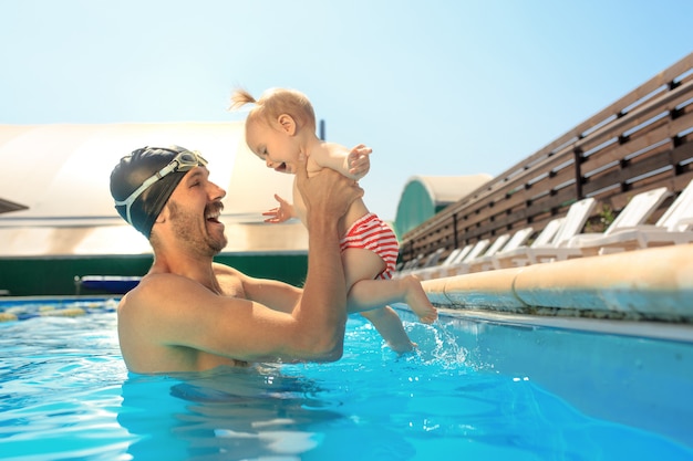 Glückliche Familie, die Spaß am Schwimmbad hat