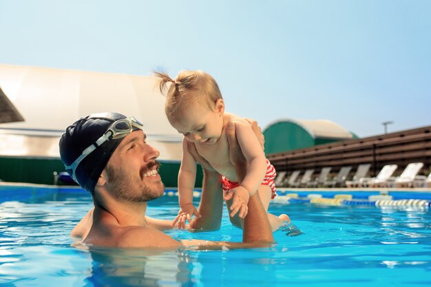 Glückliche Familie, die Spaß am Schwimmbad hat