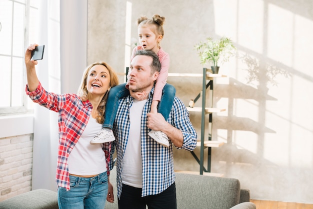 Glückliche Familie, die zu Hause selfie auf Mobiltelefon nimmt