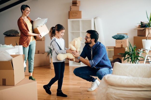 Glückliche Familie genießt es, ihre Sachen in ihr neues Zuhause zu bringen