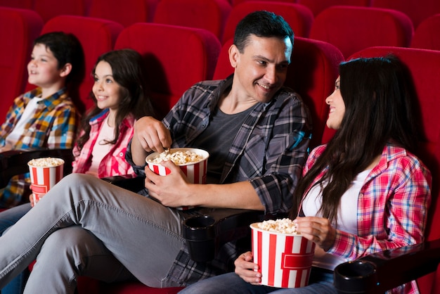 Glückliche familie im kino sitzen