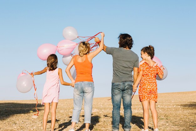 Glückliche Familie mit Ballonen in der Natur