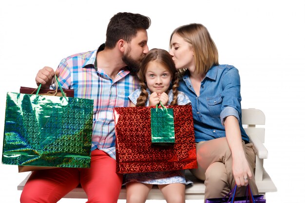 Glückliche Familie mit Einkaufstüten sitzen