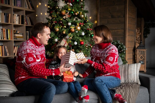 Glückliche Familie mit Geschenken mittlerer Schuss