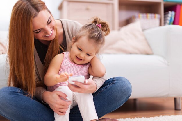 Glückliche Familie mit zeitgemäßem Handy zu Hause