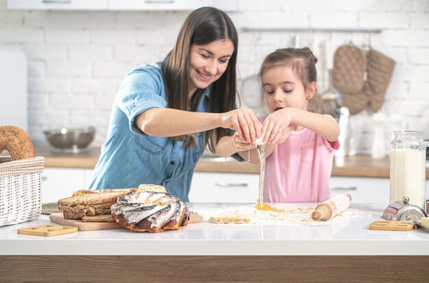 Glückliche Familie. Mutter und Tochter bereiten in der Küche Gebäck zu. Das Konzept einer liebevollen Familie und Familienwerte. Gesundes Essen zu Hause.