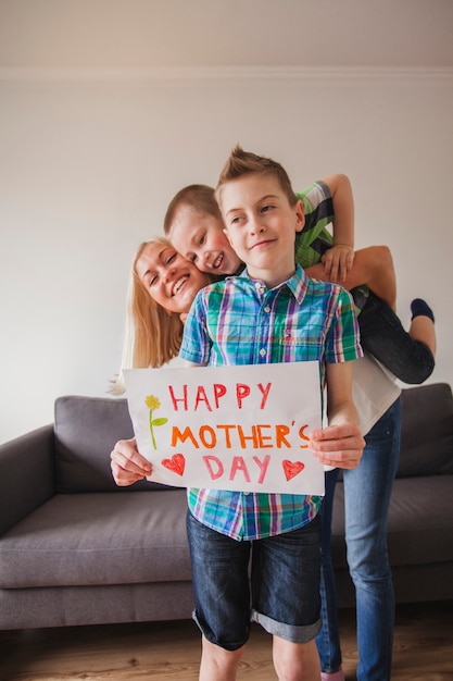 Glückliche Familie posiert mit einem Schild für Muttertag