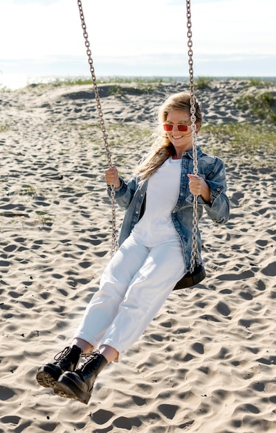 Glückliche Frau am Strand voller Schuss