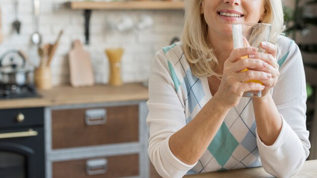 Glückliche Frau der Nahaufnahme mit Orangensaftglas