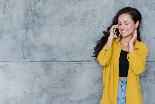 Glückliche Frau der Vorderansicht, die am Telefon spricht