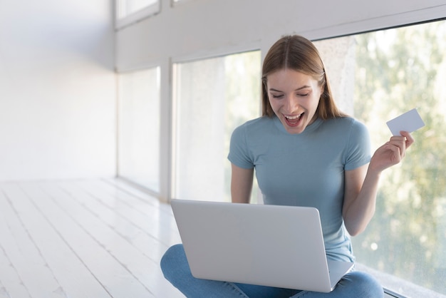 Glückliche Frau der Vorderansicht, die gute Nachrichten auf ihrem Laptop herausfindet