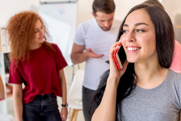 Kostenloses Foto glückliche frau, die am handy mit ihren freunden spricht