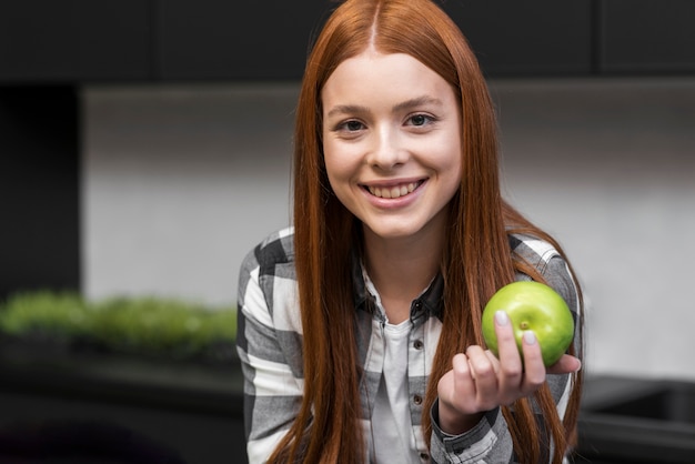 Kostenloses Foto glückliche frau, die apfel hält