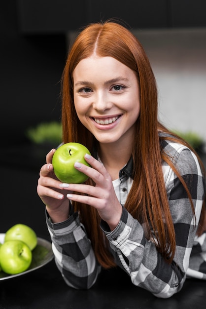 Glückliche Frau, die Apfel hält