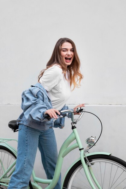 Glückliche Frau, die auf ihrem Fahrrad sitzt