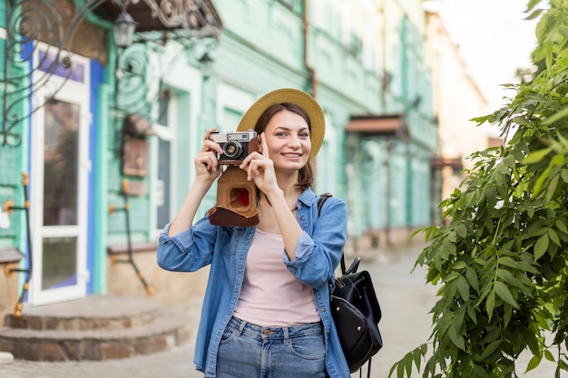 Kostenloses Foto glückliche frau, die das fotografieren im urlaub genießt