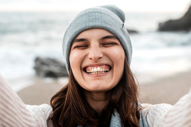 Glückliche Frau, die ein selfie am Strand nimmt