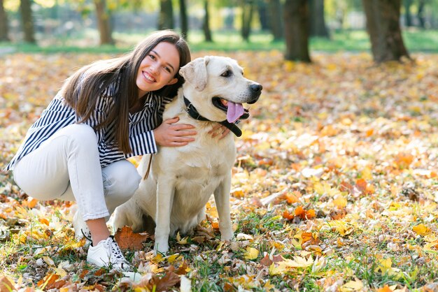 Glückliche Frau, die ihren Hund im Park umarmt