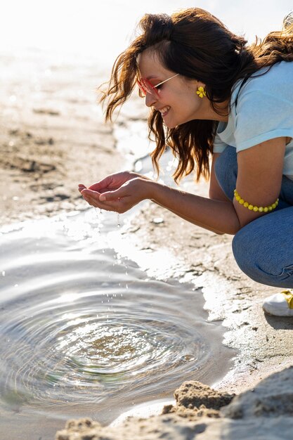 Glückliche Frau, die klares Wasser im Freien findet