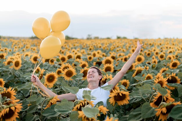 Kostenloses Foto glückliche frau, die mit luftballons aufwirft